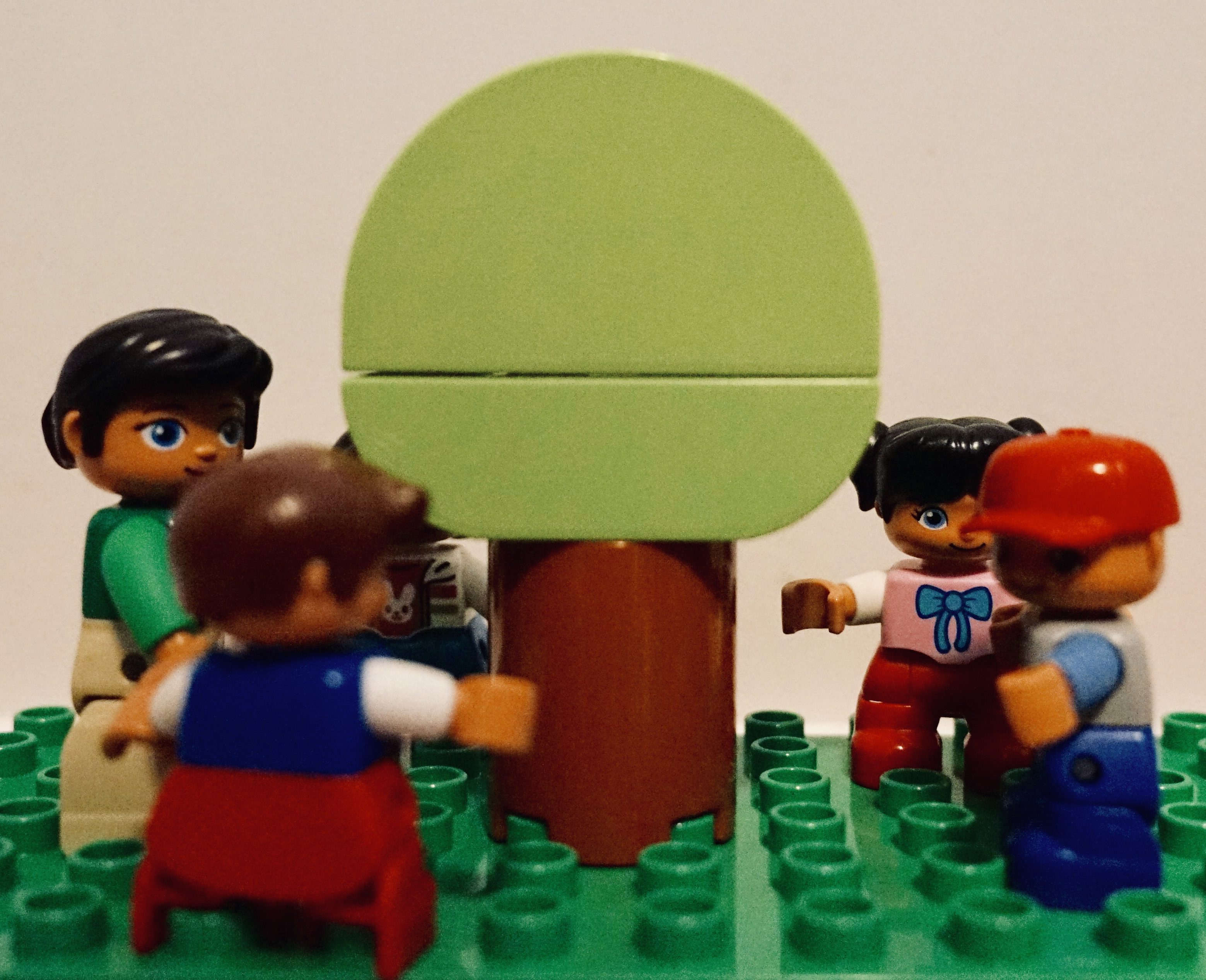 Duplo tree with figures standing in circle around it